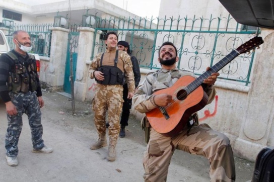 Un combattant de l'Armée Syrienne Libre joue de la guitare Un combattant de l'Armée Syrienne Libre joue de la guitare